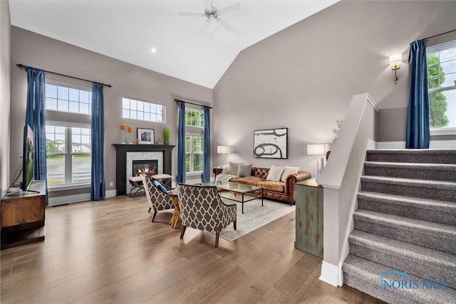 9258 Nate Ct, Sylvania, OH 43560 - living area with stairway, high vaulted ceiling, wood finished floors, ceiling fan, and a tile fireplace