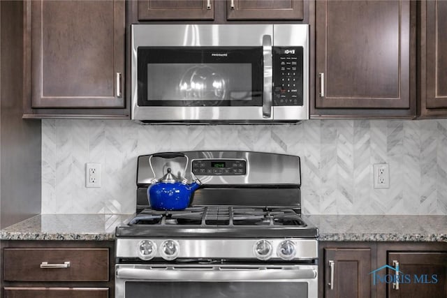 9258 Nate Ct, Sylvania, OH 43560 - kitchen featuring appliances with stainless steel finishes, dark brown cabinets, decorative backsplash, and light stone countertops