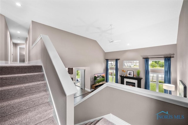 9258 Nate Ct, Sylvania, OH 43560 - stairs featuring a warm lit fireplace, a ceiling fan, recessed lighting, and high vaulted ceiling