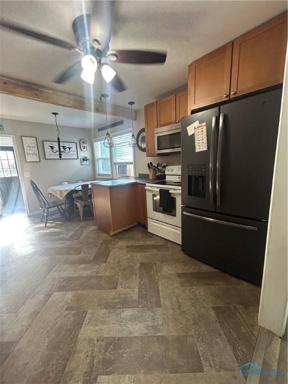 1020 Fremont Ave, Findlay, OH 45840 - kitchen featuring refrigerator with ice dispenser, electric range, stainless steel microwave, a peninsula, and brown cabinets