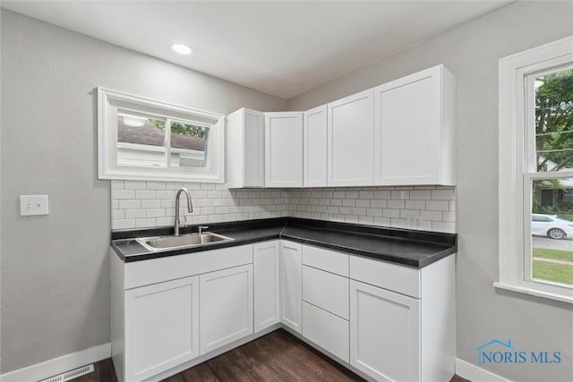 2713 Stateview Dr, Toledo, OH 43609 - kitchen with tasteful backsplash, dark countertops, white cabinetry, and dark wood finished floors