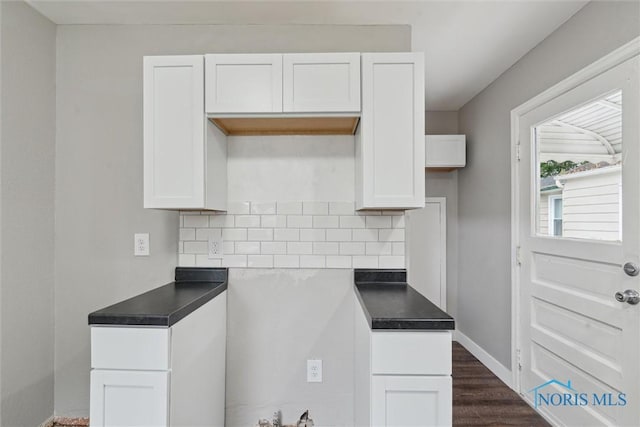 2713 Stateview Dr, Toledo, OH 43609 - kitchen with decorative backsplash, white cabinets, dark wood finished floors, and dark countertops