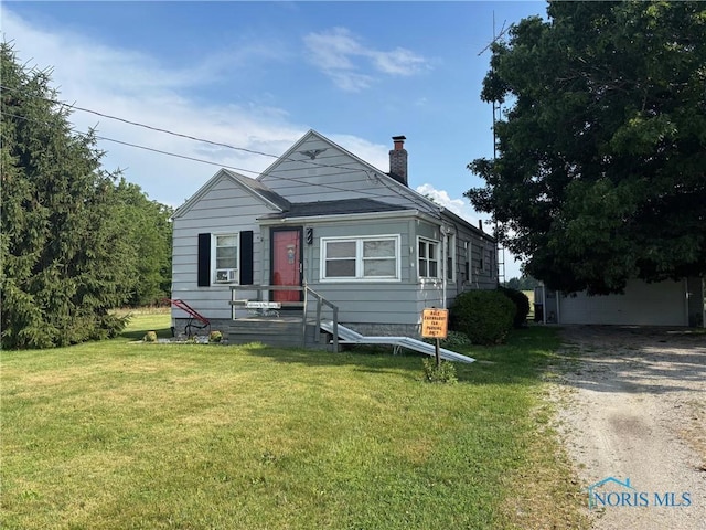 3706 Corduroy Rd, Oregon, OH 43616 - view of front of house featuring a chimney, a front lawn, and driveway