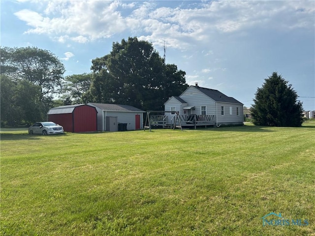 3706 Corduroy Rd, Oregon, OH 43616 - view of green lawn with a garage, a wooden deck, and a storage unit
