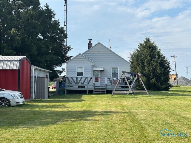 3706 Corduroy Rd, Oregon, OH 43616 - back of property featuring an outbuilding, a lawn, a wooden deck, a chimney, and a garage