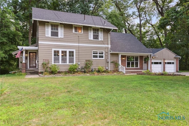 1673 Watova Rd, Toledo, OH 43614 - traditional-style house featuring a garage, a front lawn, driveway, and view of scattered trees