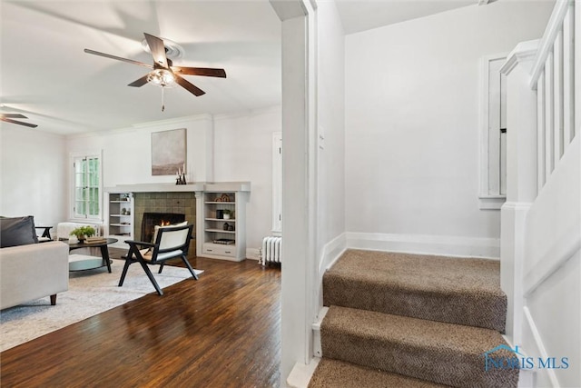 1673 Watova Rd, Toledo, OH 43614 - stairs with radiator heating unit, ceiling fan, a tiled fireplace, and wood finished floors