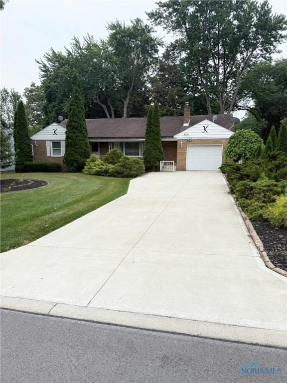 125 E Yates Ave, Findlay, OH 45840 - ranch-style home with concrete driveway, a front yard, a garage, and a chimney
