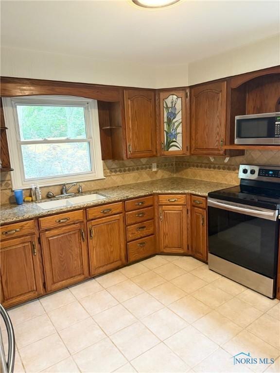 125 E Yates Ave, Findlay, OH 45840 - kitchen with appliances with stainless steel finishes, open shelves, tasteful backsplash, brown cabinets, and light stone counters