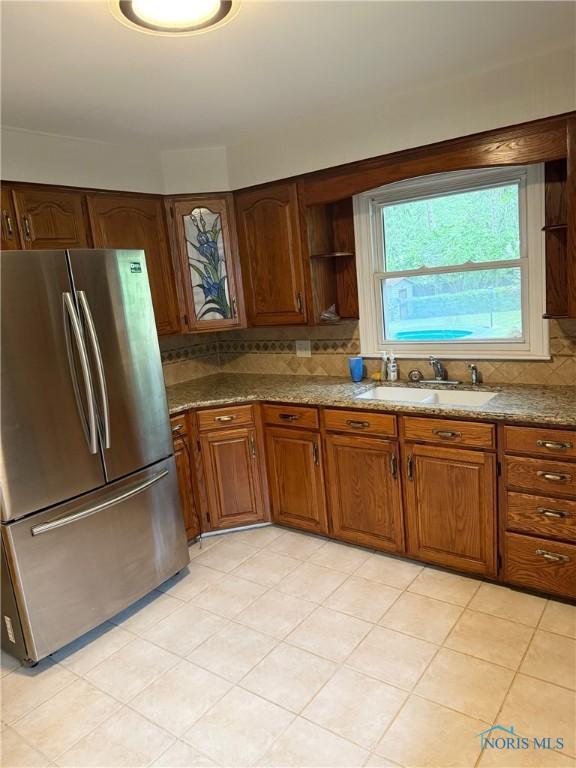 125 E Yates Ave, Findlay, OH 45840 - kitchen featuring freestanding refrigerator, decorative backsplash, open shelves, and brown cabinets
