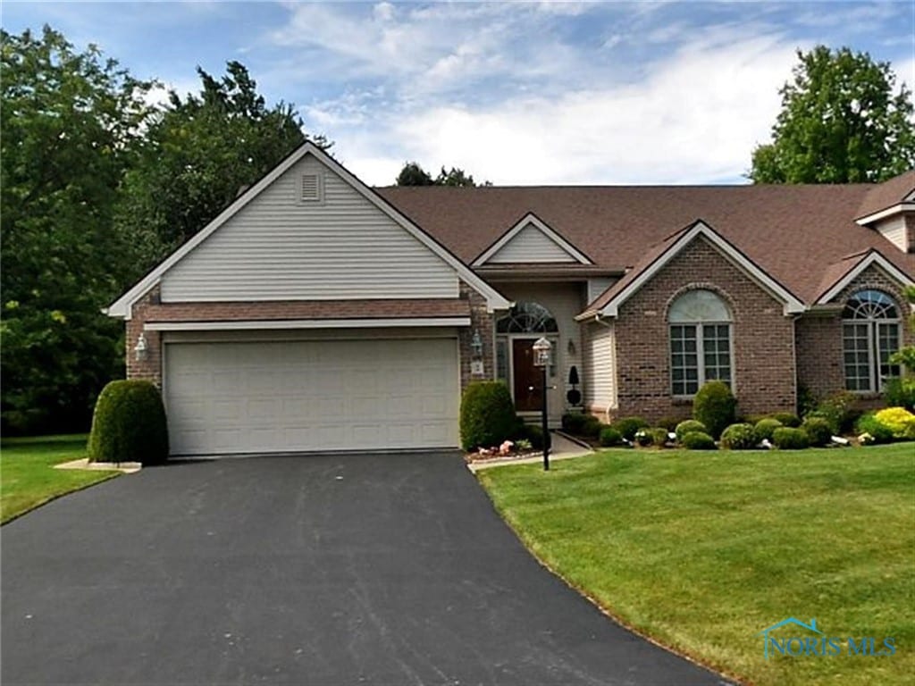 2 Shenandoah Cir, Sylvania, OH 43560 - view of front of home featuring asphalt driveway, brick siding, a front yard, and a garage