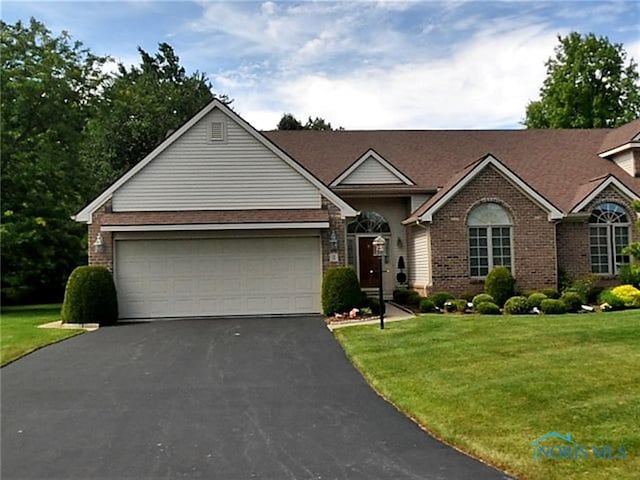 2 Shenandoah Cir, Sylvania, OH 43560 - view of front of home featuring asphalt driveway, brick siding, a front yard, and a garage