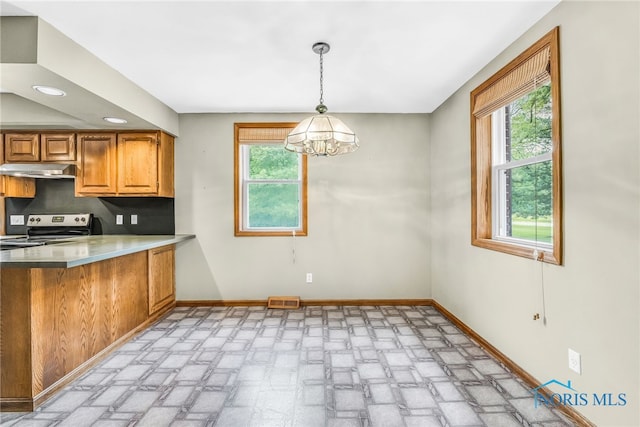 21010 Lemoyne Rd, Luckey, OH 43443 - kitchen featuring under cabinet range hood, electric range, plenty of natural light, brown cabinetry, and recessed lighting