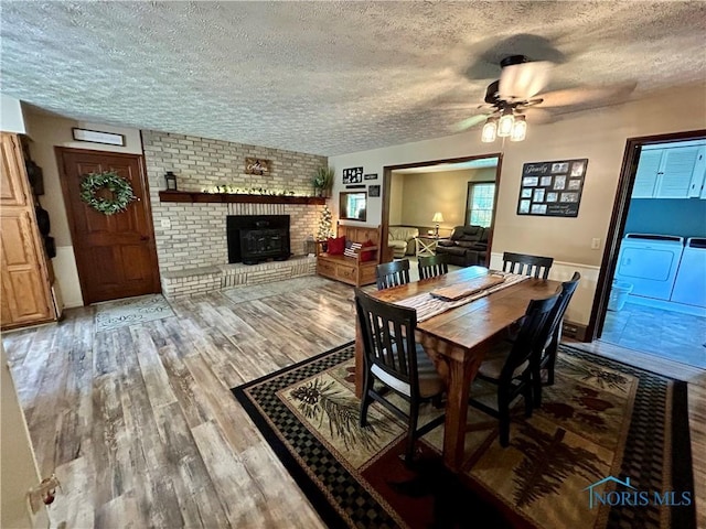 210 Duck Pond Rd, Upper Sandusky, OH 43351 - dining area featuring independent washer and dryer, a textured ceiling, wood finished floors, a ceiling fan, and a fireplace