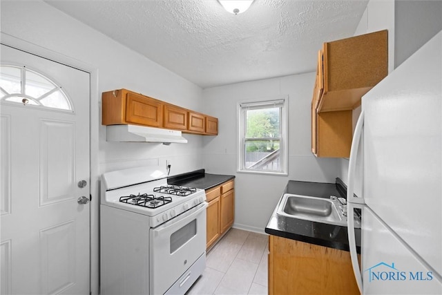 5520 N Summit St, Toledo, OH 43611 - kitchen with white appliances, under cabinet range hood, a textured ceiling, brown cabinetry, and dark countertops