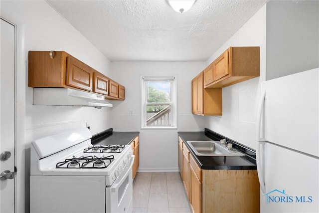 5520 N Summit St, Toledo, OH 43611 - kitchen featuring white appliances, under cabinet range hood, a textured ceiling, dark countertops, and brown cabinets