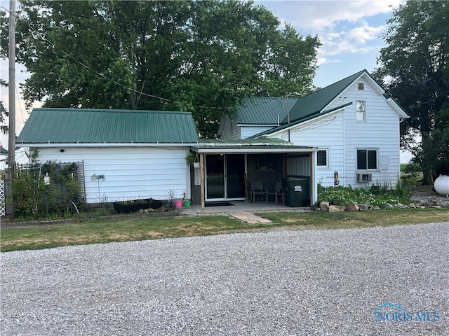 8872 Rd 87, Paulding, OH 45879 - rear view of house featuring a metal roof, gravel driveway, and a sunroom