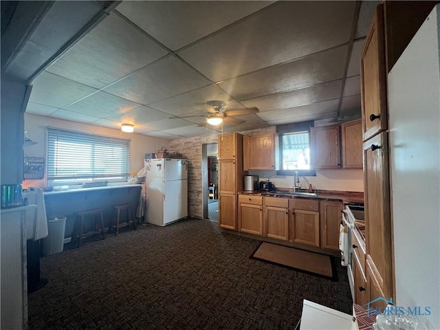8872 Rd 87, Paulding, OH 45879 - kitchen with freestanding refrigerator, ceiling fan, a paneled ceiling, dark countertops, and dark carpet