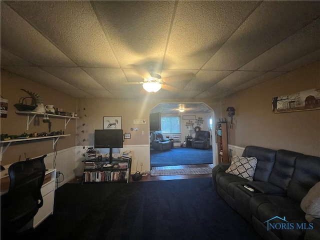 8872 Rd 87, Paulding, OH 45879 - living room featuring ceiling fan, arched walkways, a paneled ceiling, and wainscoting