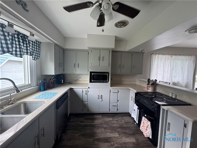 1926 Tiffin Rd, Fremont, OH 43420 - kitchen featuring stainless steel microwave, ceiling fan, dishwashing machine, dark wood-type flooring, and gray cabinetry