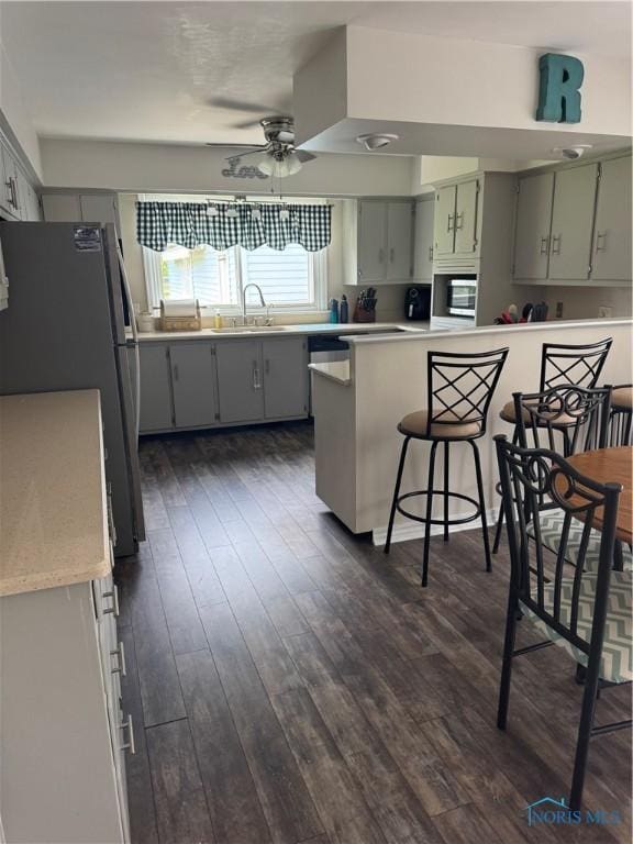 1926 Tiffin Rd, Fremont, OH 43420 - kitchen featuring freestanding refrigerator, dark wood-type flooring, ceiling fan, and gray cabinetry