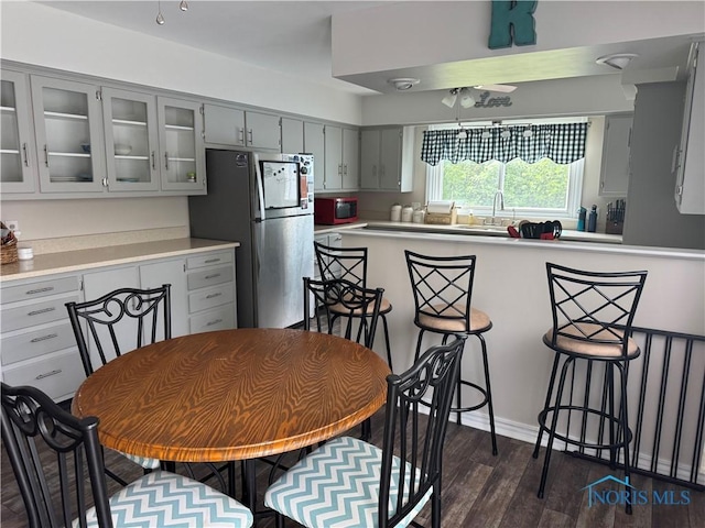 1926 Tiffin Rd, Fremont, OH 43420 - kitchen with freestanding refrigerator, gray cabinets, glass insert cabinets, and dark wood-style floors
