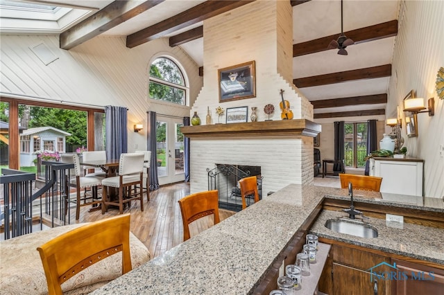 618 Sutton Pl, Findlay, OH 45840 - living area with beamed ceiling, hardwood / wood-style flooring, a brick fireplace, high vaulted ceiling, and a ceiling fan