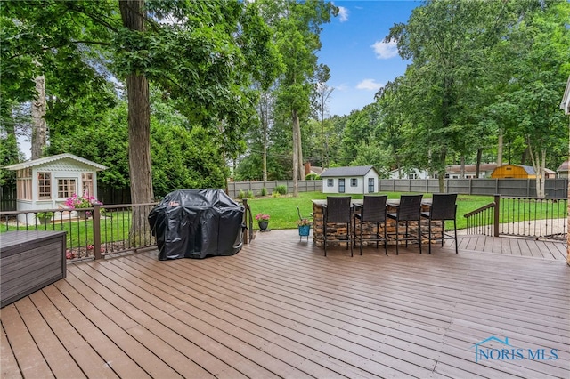 618 Sutton Pl, Findlay, OH 45840 - wooden deck featuring area for grilling, a fenced backyard, view of scattered trees, and a shed
