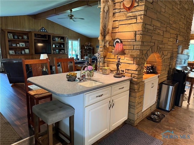 19445 Powers Rd, Defiance, OH 43512 - kitchen featuring white cabinets, a ceiling fan, wooden walls, light countertops, and a breakfast bar area