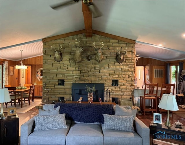 19445 Powers Rd, Defiance, OH 43512 - living room featuring a ceiling fan, wood finished floors, wooden walls, and a stone fireplace