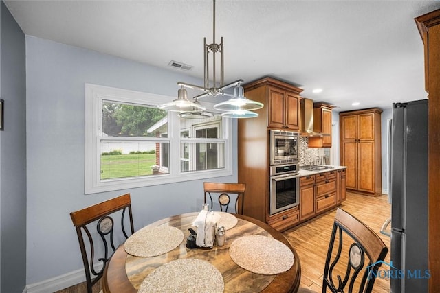 3605 W Laskey Rd, Toledo, OH 43623 - kitchen with stainless steel appliances, brown cabinets, light wood-type flooring, decorative backsplash, and recessed lighting