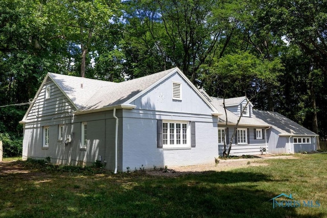 4906 Pine Ridge Rd, Toledo, OH 43615 - view of front of house with a front lawn, roof with shingles, view of scattered trees, and brick siding