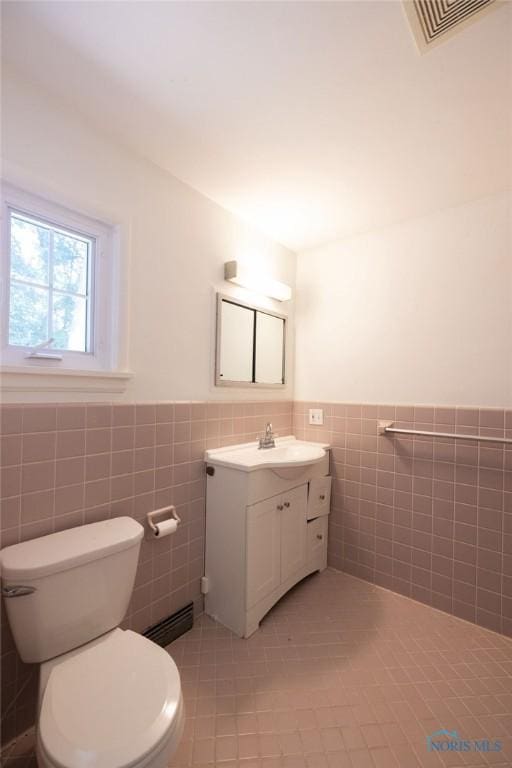 4906 Pine Ridge Rd, Toledo, OH 43615 - bathroom with vanity, tile walls, wainscoting, and tile patterned floors