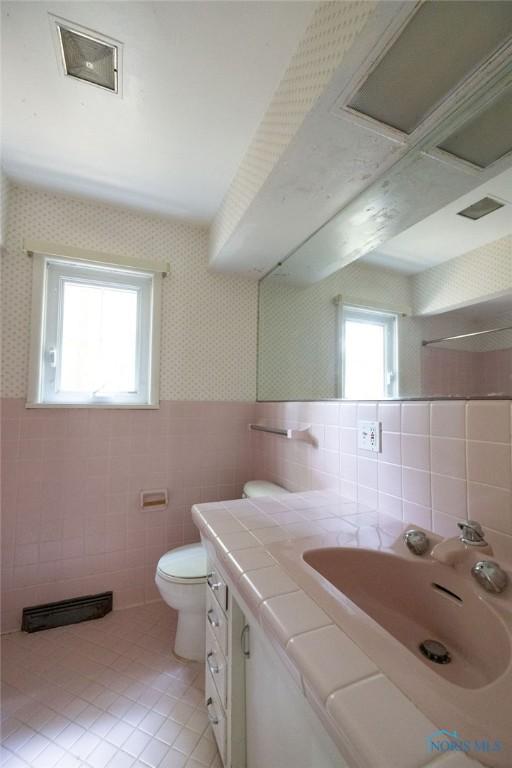 4906 Pine Ridge Rd, Toledo, OH 43615 - bathroom with tile walls, tile patterned flooring, vanity, wallpapered walls, and wainscoting