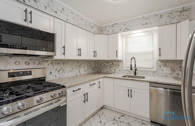4308 Willis Blvd, Toledo, OH 43623 - kitchen with stainless steel appliances, light marble finish floors, white cabinets, light stone counters, and tasteful backsplash