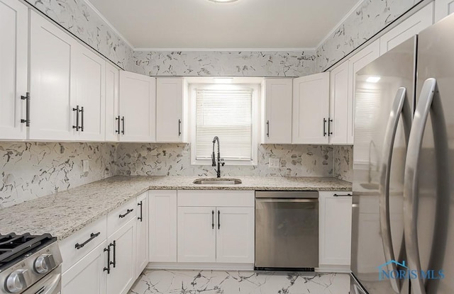 4308 Willis Blvd, Toledo, OH 43623 - kitchen featuring appliances with stainless steel finishes, white cabinetry, light marble finish floors, light stone countertops, and ornamental molding