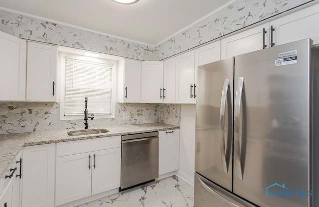 4308 Willis Blvd, Toledo, OH 43623 - kitchen featuring appliances with stainless steel finishes, white cabinets, light marble finish floors, light stone counters, and ornamental molding