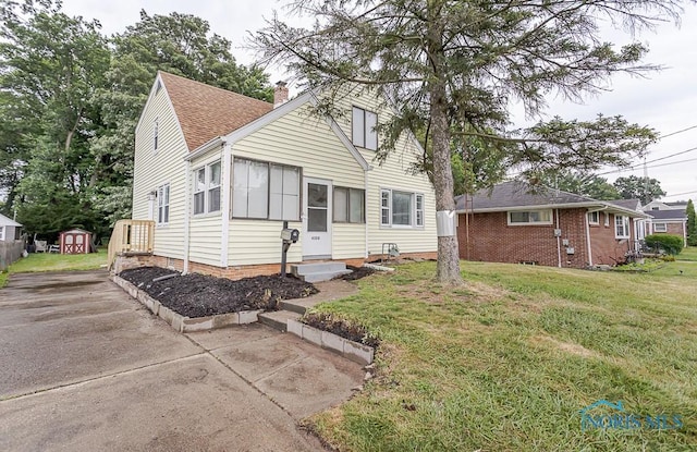 4308 Willis Blvd, Toledo, OH 43623 - bungalow with entry steps, a chimney, a front yard, roof with shingles, and concrete driveway