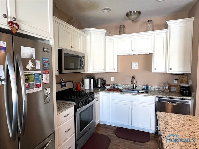 410 Spring St, Upper Sandusky, OH 43351 - kitchen with stainless steel appliances, white cabinetry, light stone countertops, and dark wood-type flooring