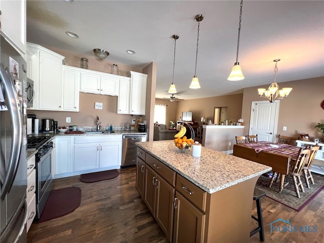410 Spring St, Upper Sandusky, OH 43351 - kitchen featuring stainless steel appliances, dark wood-style flooring, a center island, white cabinetry, and light stone countertops