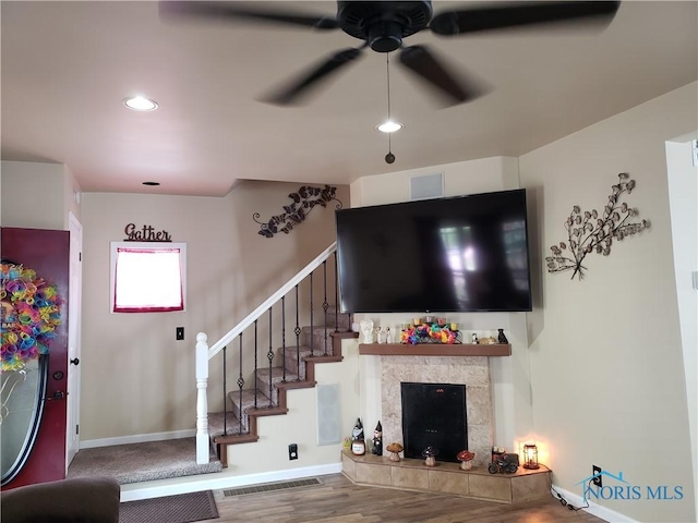 254 Fremont St, Elmore, OH 43416 - living area featuring a ceiling fan, stairs, recessed lighting, wood finished floors, and a tiled fireplace