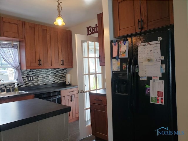 254 Fremont St, Elmore, OH 43416 - kitchen with black appliances, tasteful backsplash, dark countertops, brown cabinets, and pendant lighting