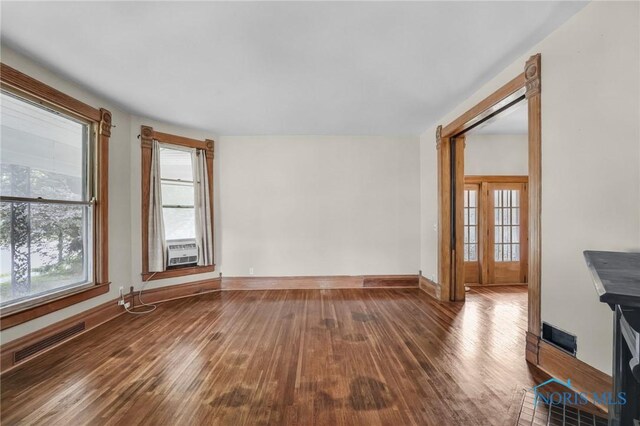 2008 N Main St, Findlay, OH 45840 - unfurnished living room featuring hardwood / wood-style flooring, healthy amount of natural light, and cooling unit