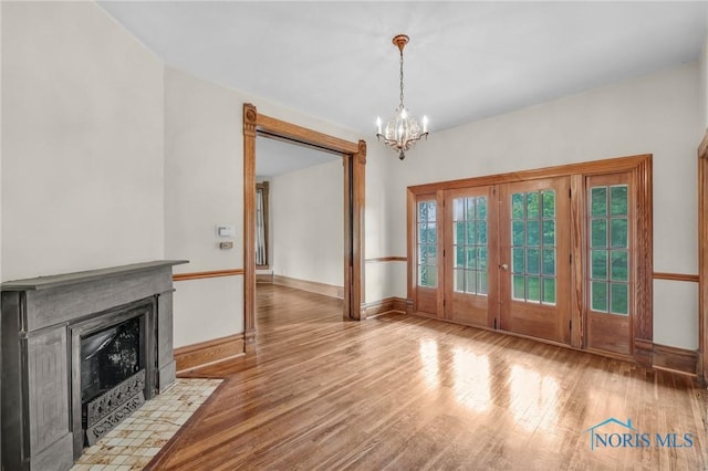 2008 N Main St, Findlay, OH 45840 - unfurnished dining area featuring a chandelier, wood finished floors, french doors, and a fireplace with flush hearth