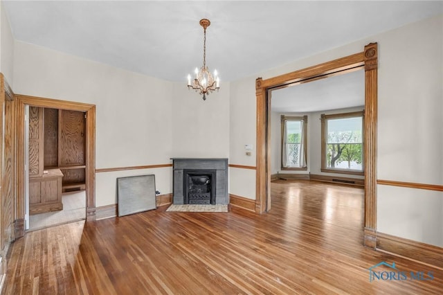 2008 N Main St, Findlay, OH 45840 - unfurnished living room featuring wood finished floors, a chandelier, and a fireplace