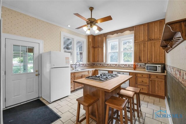 2008 N Main St, Findlay, OH 45840 - kitchen featuring stainless steel appliances, wood counters, plenty of natural light, wallpapered walls, and a kitchen breakfast bar