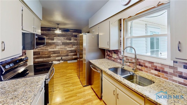 11232 Elm St, Dunbridge, OH 43414 - kitchen with appliances with stainless steel finishes, light wood finished floors, tasteful backsplash, ceiling fan, and wood walls