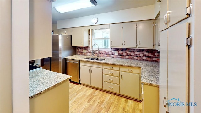 11232 Elm St, Dunbridge, OH 43414 - kitchen with dishwasher, decorative backsplash, light wood-style floors, and light stone counters