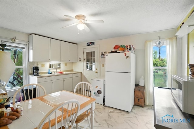5660 Rd 180, Antwerp, OH 45813 - kitchen with white appliances, plenty of natural light, ceiling fan, white cabinets, and a textured ceiling