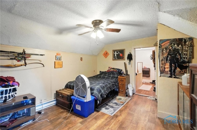 5660 Rd 180, Antwerp, OH 45813 - bedroom featuring wood finished floors, a baseboard heating unit, vaulted ceiling, a textured ceiling, and a ceiling fan